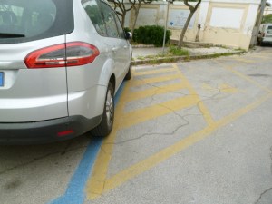Here we see a car parked in blue stripes (pay) but overlapping onto yellow (reserved in this case for handicapped).