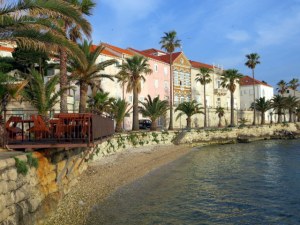 Along the Korčula waterfront in the morning, soft light, pastel colors.