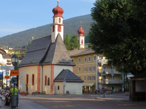 Ortisei in the morning. The two steeples look the same size from this perspective, but the closer one is a fraction of the size of the big church on the hill. 