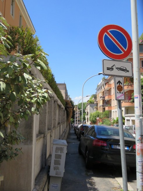 This is our street. We live in the orangey-pink building on the left. Note the tow-away zone yet cars parked half-on-half-off the sidewalk. There is a sticker on the sign right below the arrow that says "Capito?" Ha! Never, ever do they enforce the parking law here. 