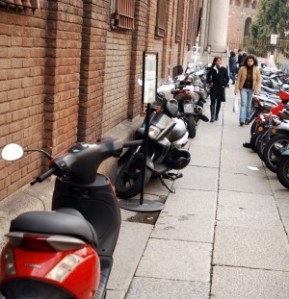 Not unusual to see the sidewalk as a parking lot for motorini, and frequently one or more are in motion. 